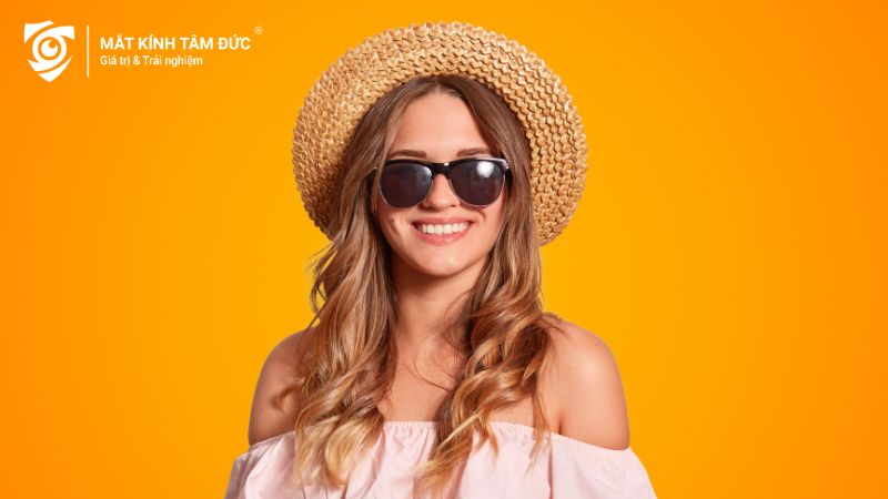 Cô gái mặc đồ mùa hè cùng chiếc kính thời trang trên nền cam