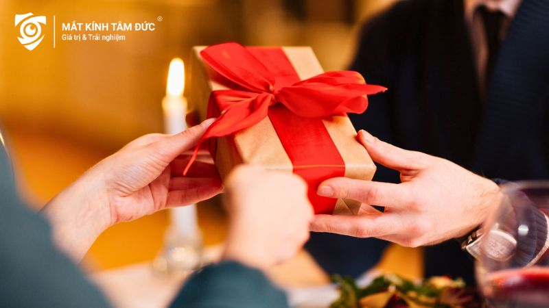 Cô gái tặng quà Valentine cho bạn trai trong khung cảnh nhà hàng lãng mạn