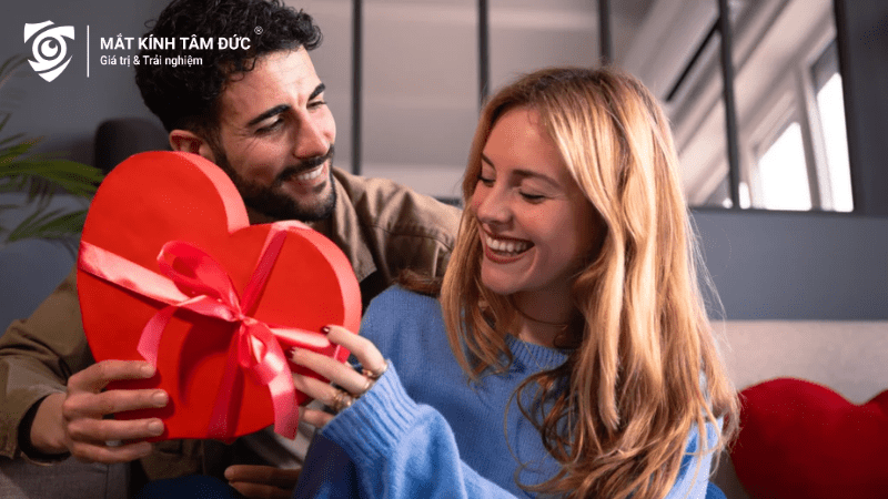 Chàng trai tặng hộp quà Valentine hình trái tim cho cô gái, một cặp đôi hạnh phúc