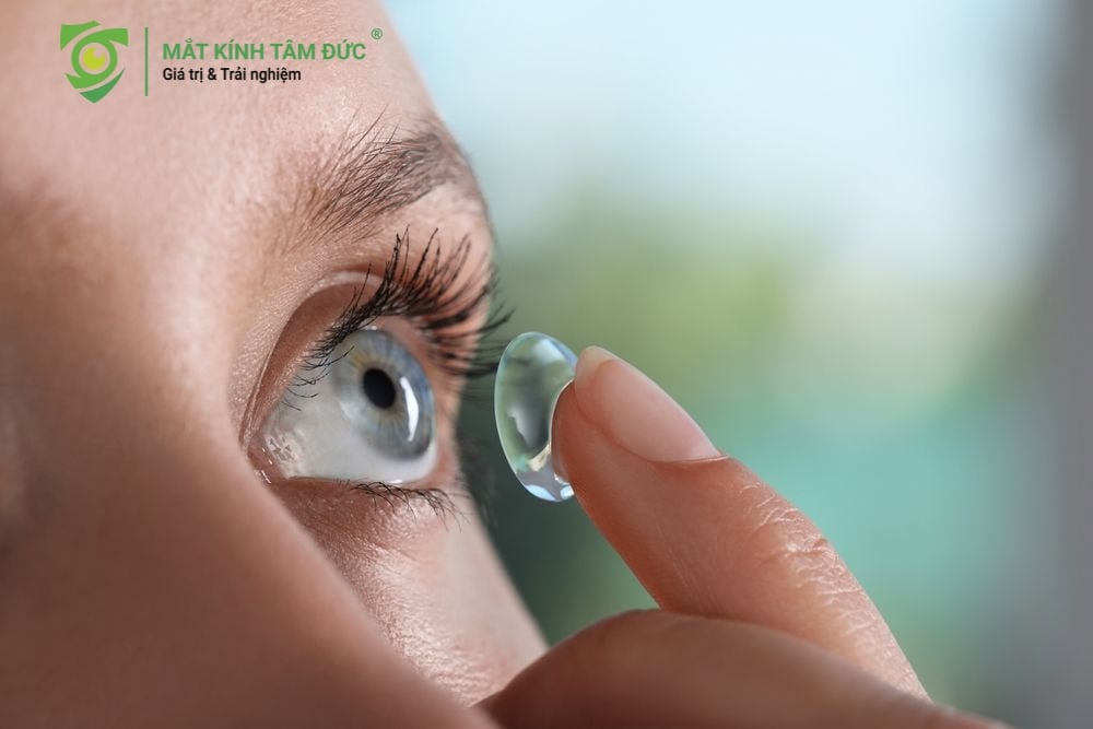 Cận cảnh ngón tay đặt kính áp tròng lên mắt