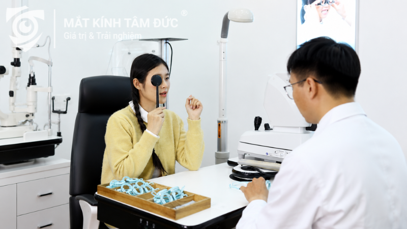 Chuyên viên mắt kính tư vấn chọn tròng kính siêu mỏng cho khách hàng tại cửa hàng